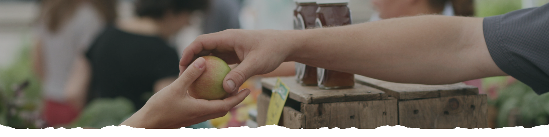 passing an apple to someone in a marketplace